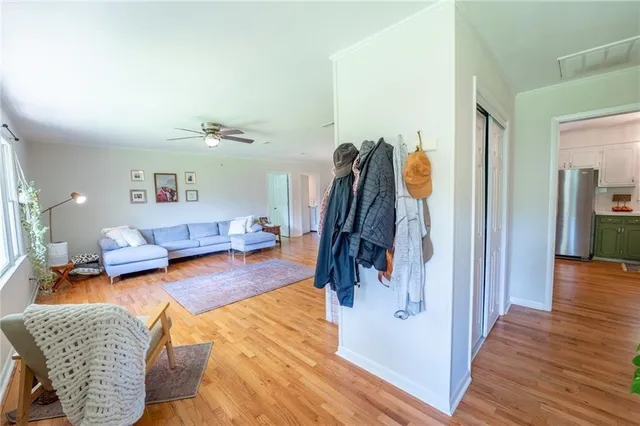 a view of a hallway with wooden floor and a bathroom