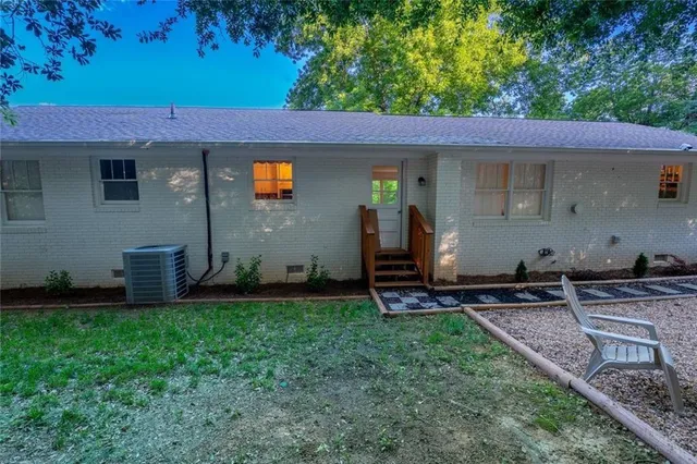 a backyard of a house with chairs and wooden fence