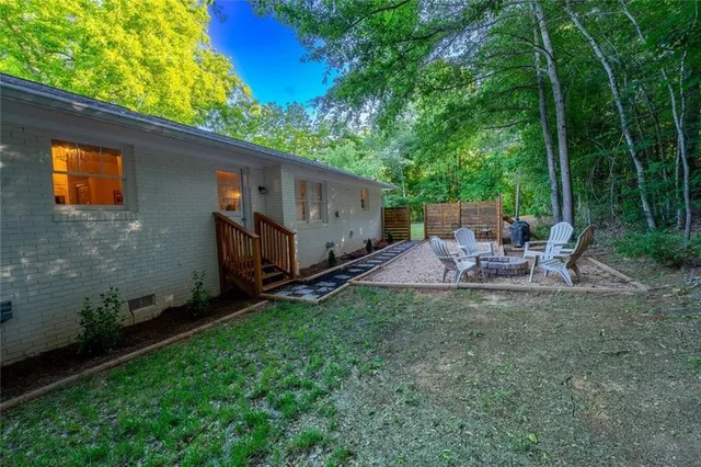 a view of a house with a small yard and wooden fence