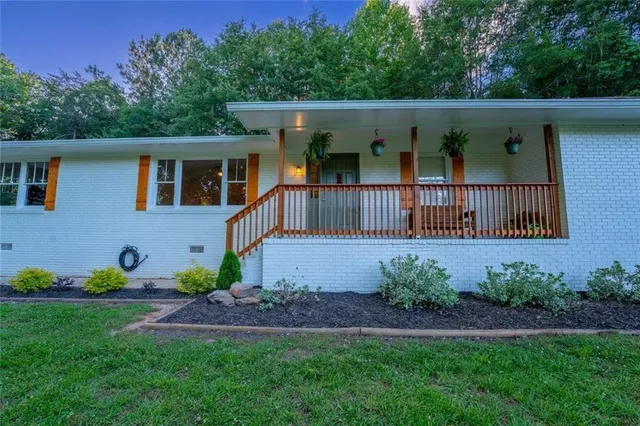 a view of a house with a small yard and deck
