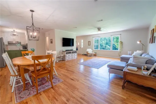 a hallway with painting on the wall and a potted plant