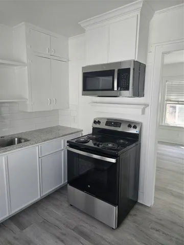 a kitchen with stainless steel appliances a stove microwave and sink