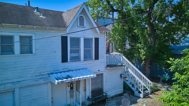 a view of wooden house with a tree front