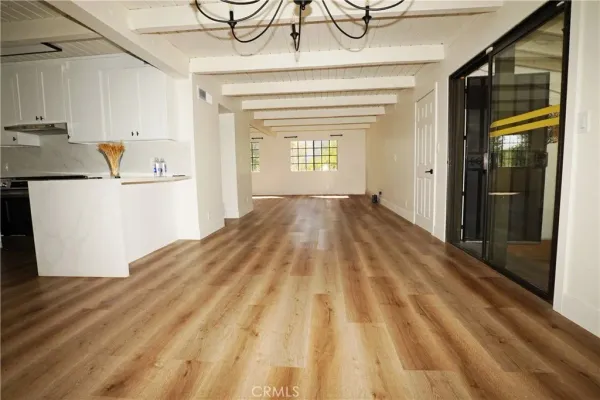 a view of empty room with wooden floor and cabinets