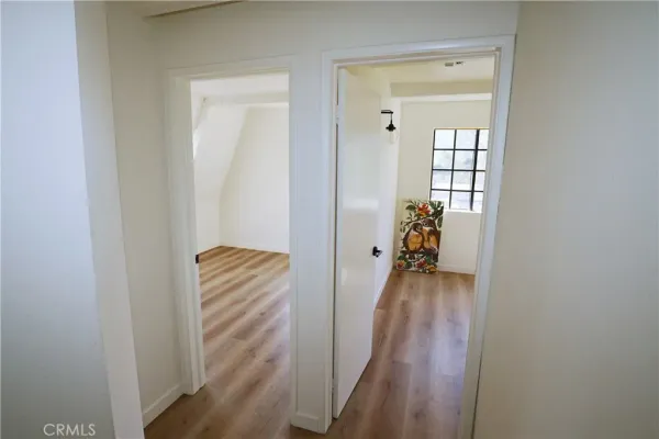 a view of a hallway with wooden floor and closet
