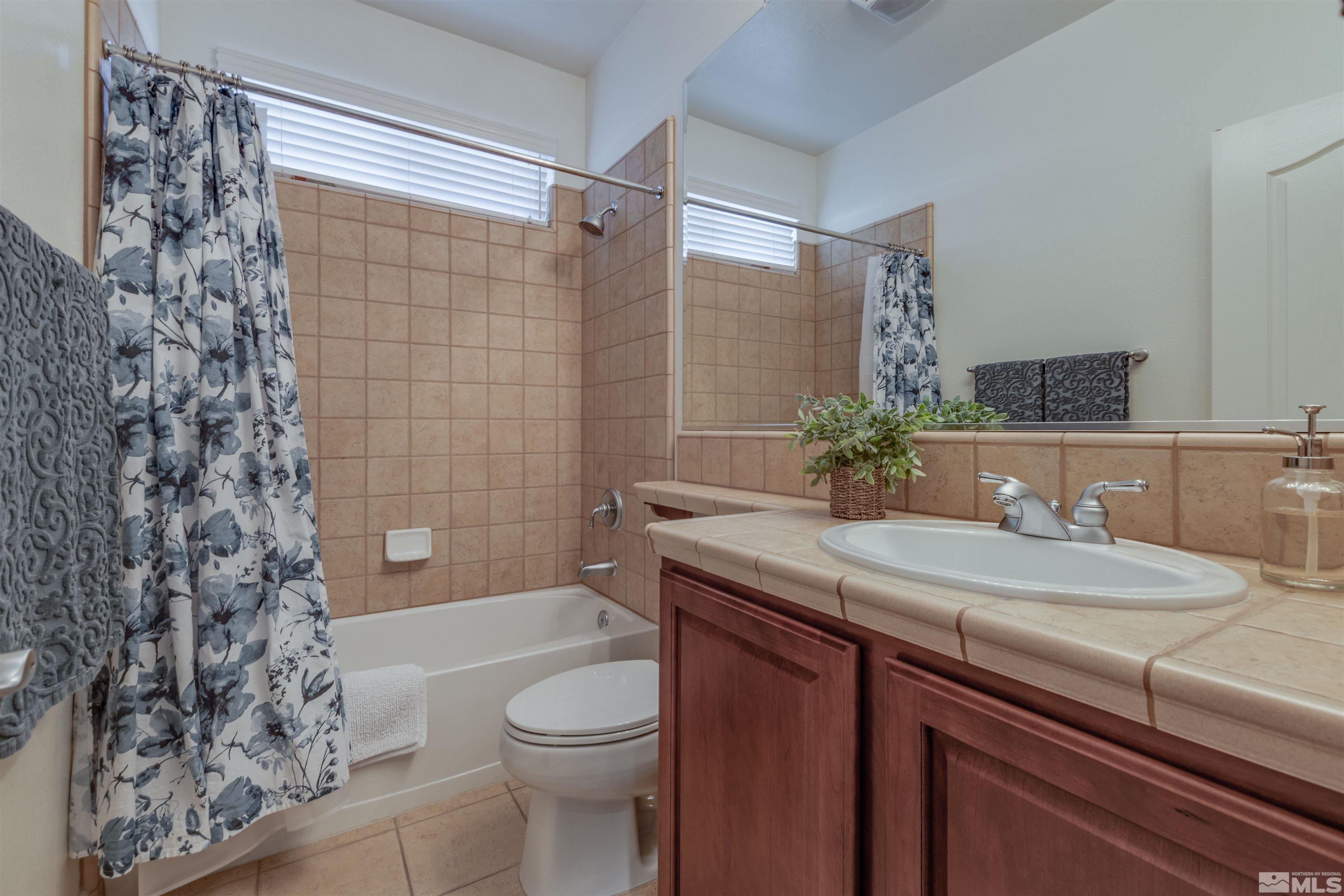450 Haleb Court Reno, NV 89521 - Photo 29 of 31 a bathroom with a granite countertop sink a toilet a mirror and shower