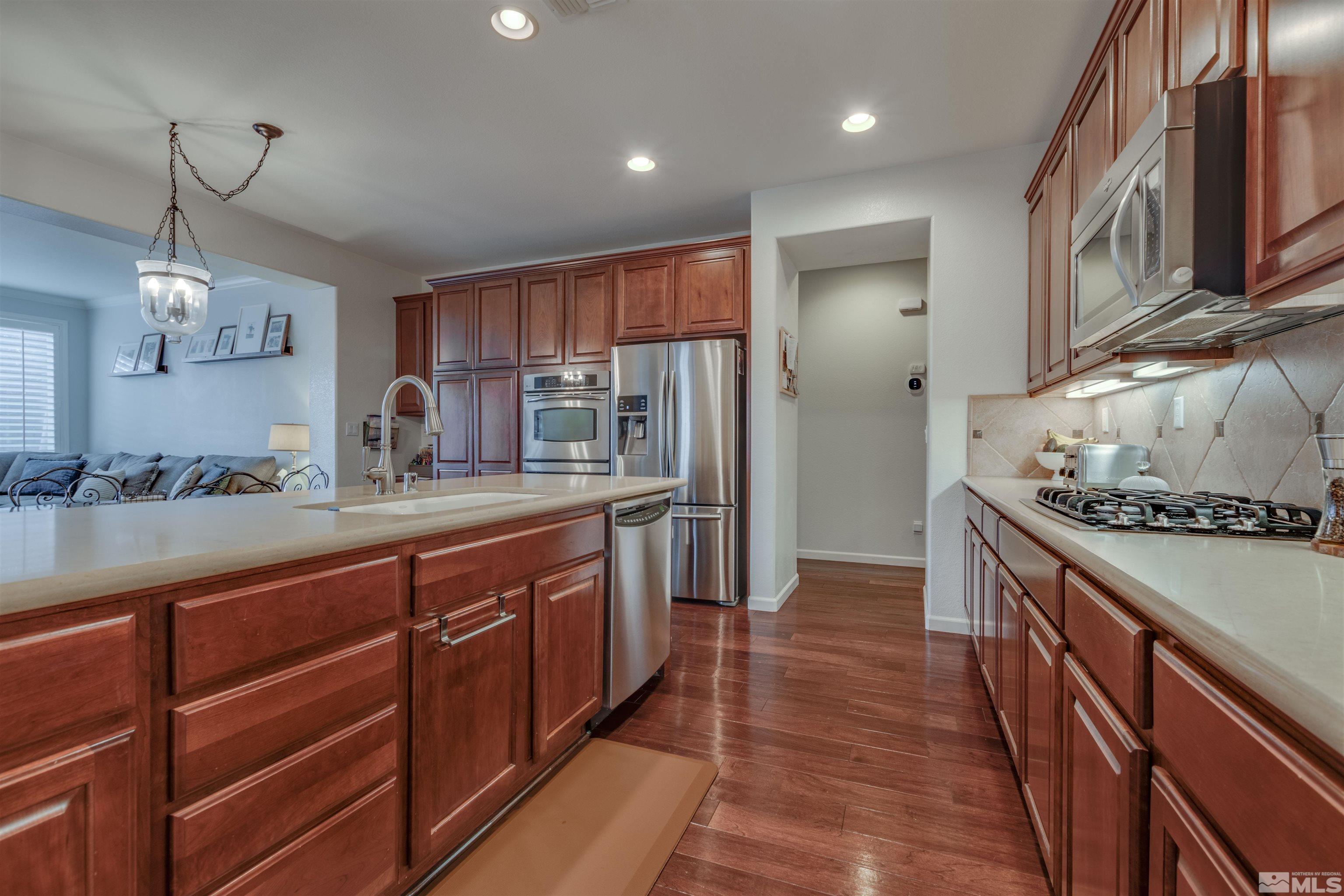 450 Haleb Court Reno, NV 89521 - Photo 9 of 31 a kitchen with stainless steel appliances granite countertop a stove a sink and a refrigerator