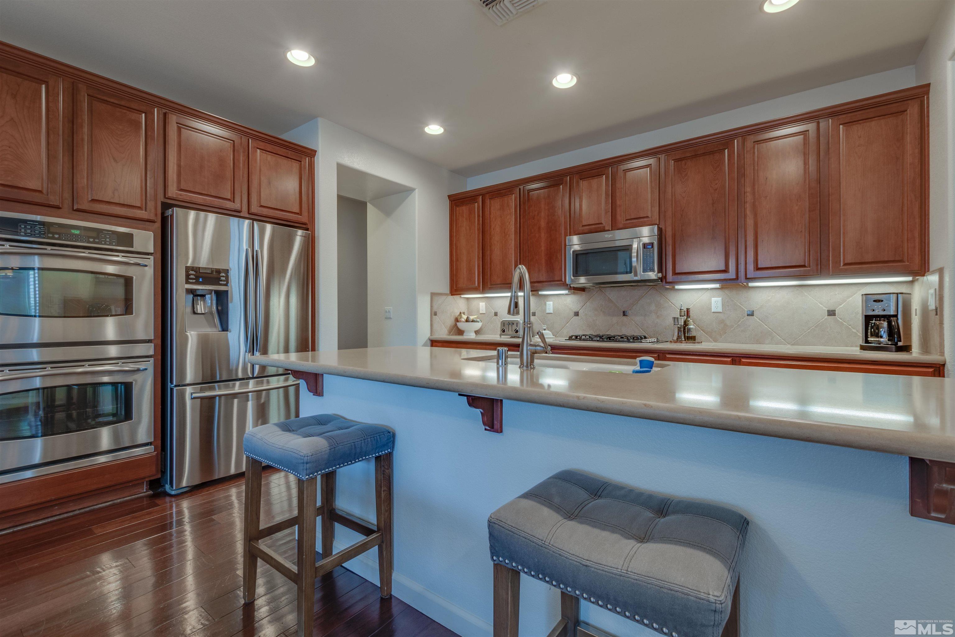450 Haleb Court Reno, NV 89521 - Photo 10 of 31 a kitchen with stainless steel appliances granite countertop a stove refrigerator sink and cabinets
