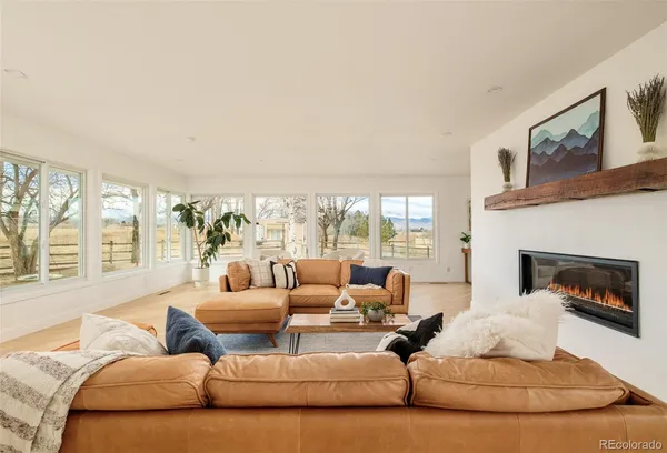 a living room with furniture large window and a fireplace