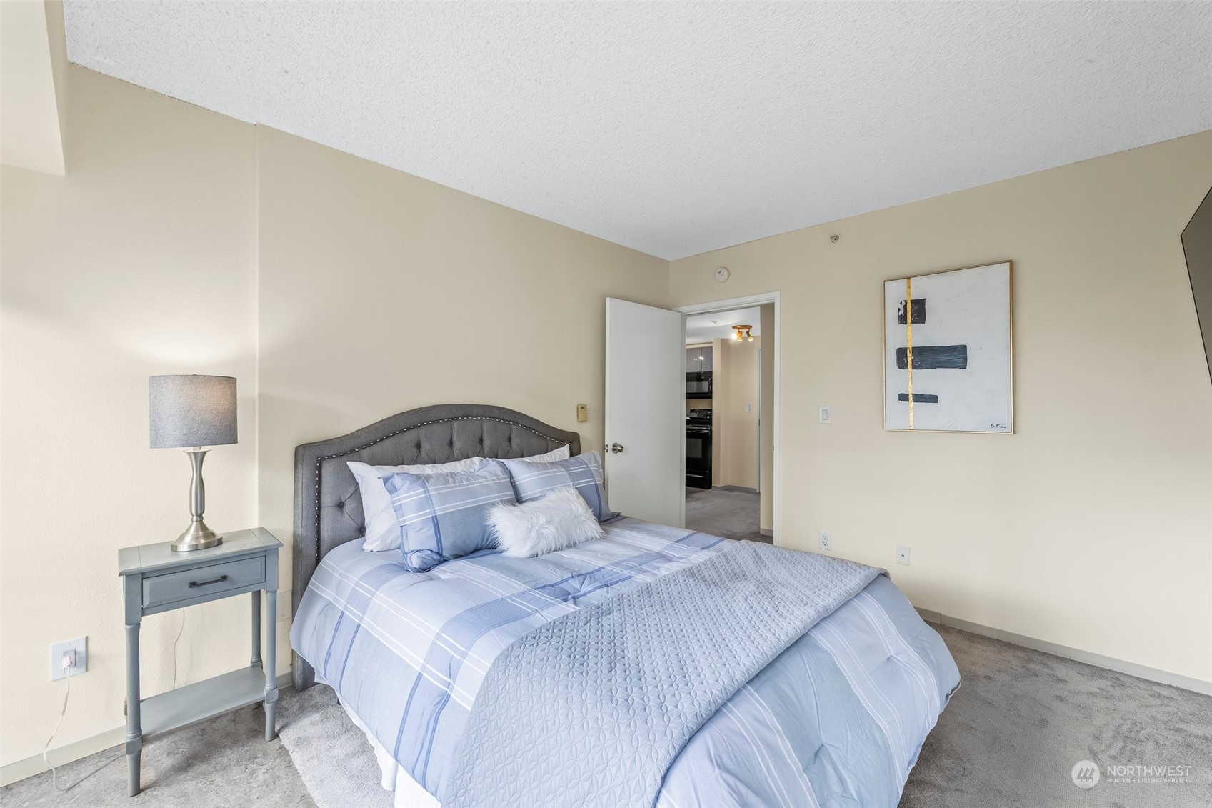 1415 2nd Avenue, Unit 1408 Seattle, WA 98101 - Photo 14 of 32 a bedroom with a bed and a lamp
