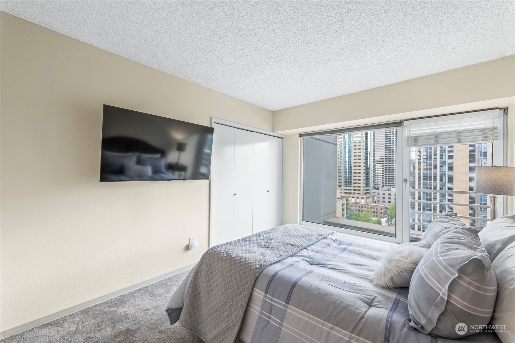 1415 2nd Avenue, Unit 1408 Seattle, WA 98101 - Photo 15 of 32 a bedroom with a bed and a flat screen tv
