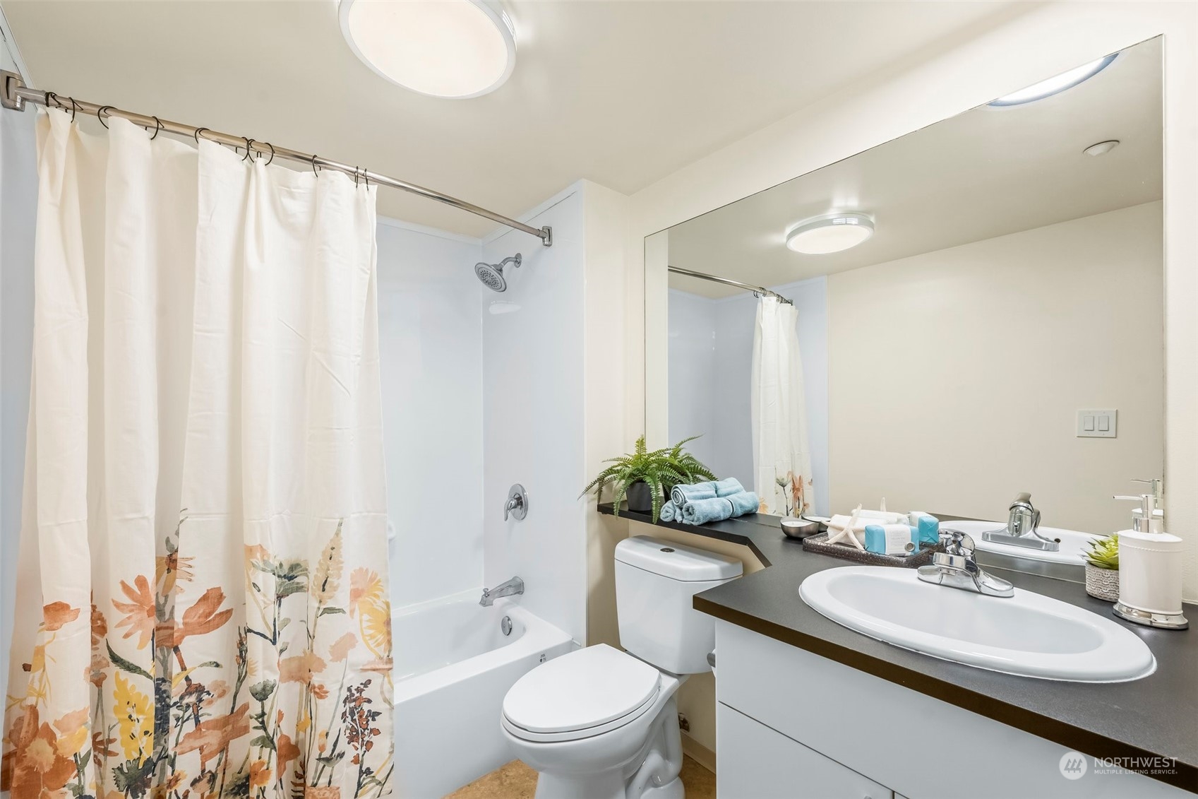 1415 2nd Avenue, Unit 1408 Seattle, WA 98101 - Photo 18 of 32 a bathroom with a sink vanity mirror and toilet