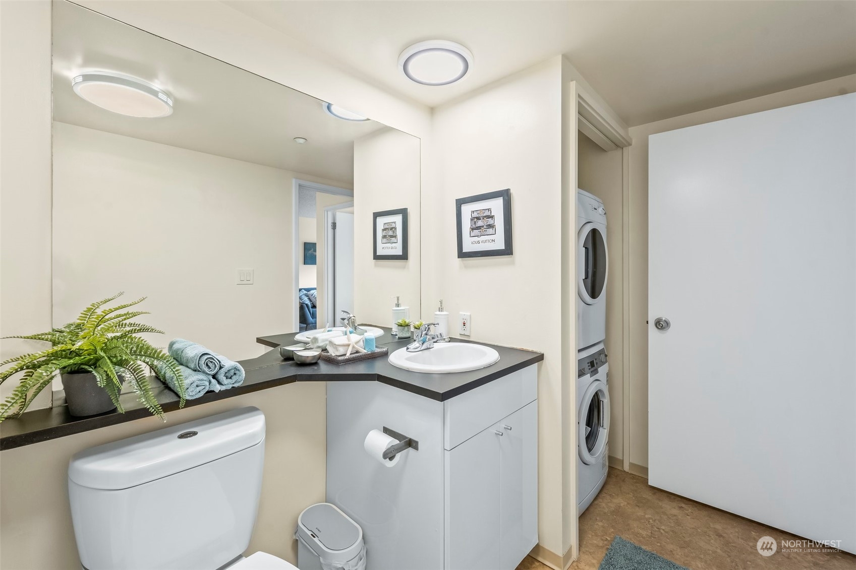 1415 2nd Avenue, Unit 1408 Seattle, WA 98101 - Photo 19 of 32 a bathroom with a granite countertop sink a toilet and mirror