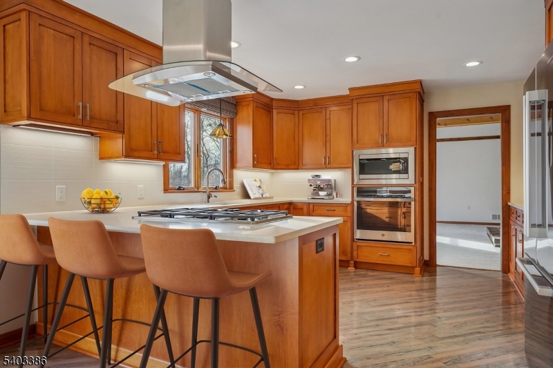 80 Spring Valley Road Morristown, NJ 07960 - Photo 10 of 48 a kitchen with stainless steel appliances granite countertop a stove a refrigerator a sink a dining table and chairs with wooden floor