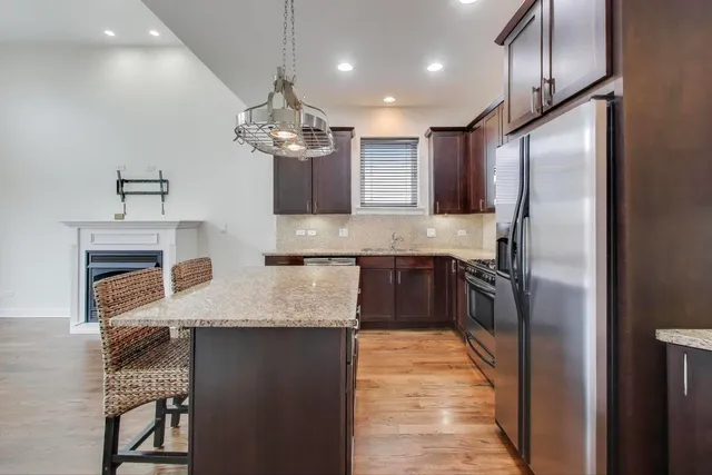 a kitchen with kitchen island granite countertop stainless steel appliances cabinets a sink and a counter top space