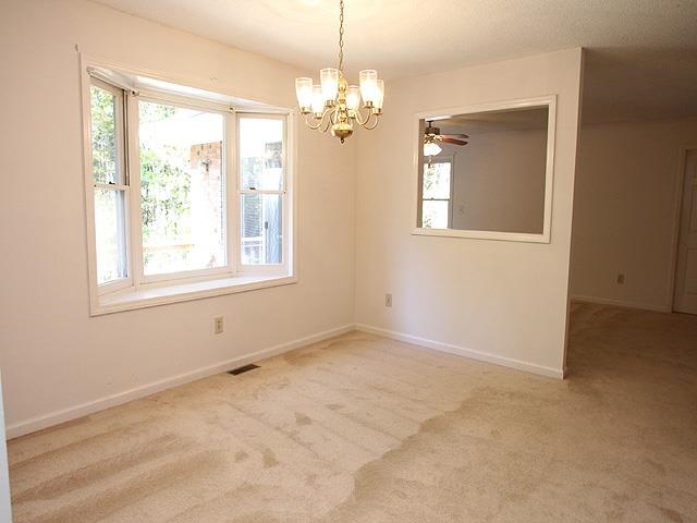 152 Stagecrest Drive Raleigh, NC 27603 - Photo 5 of 14 en empty room with windows and chandelier