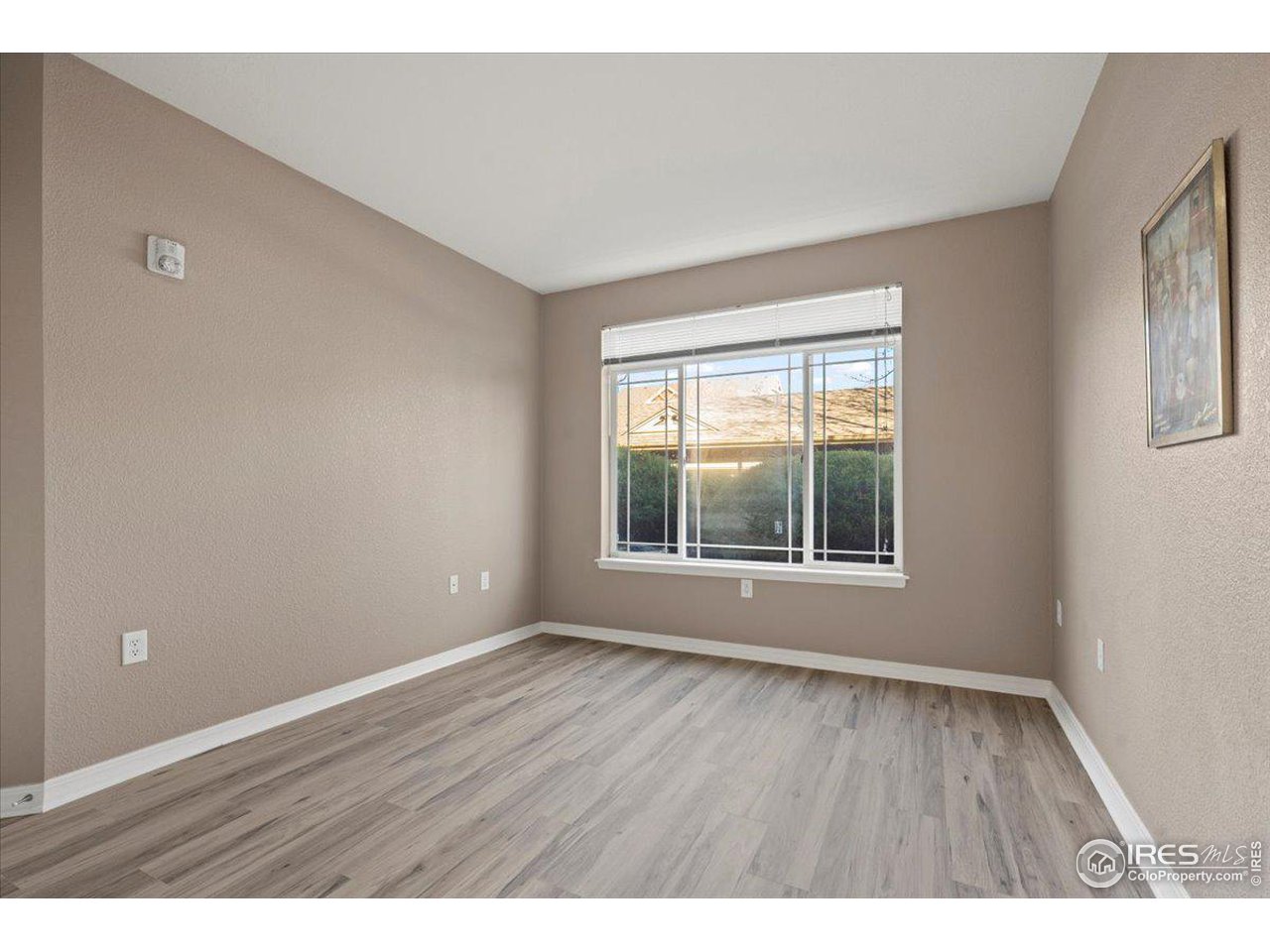 2133 Krisron Road, Unit 101 Fort Collins, CO 80525 - Photo 16 of 22 a view of an empty room with wooden floor and a window