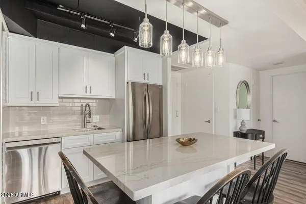 a kitchen with stainless steel appliances a table chairs and a refrigerator