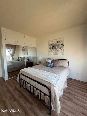 a bedroom with bed and wooden floor