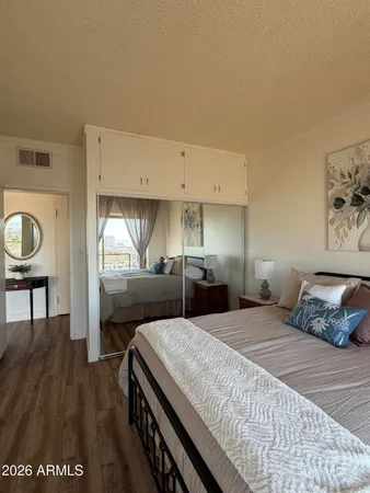 a bedroom with a bed and dresser with mirror