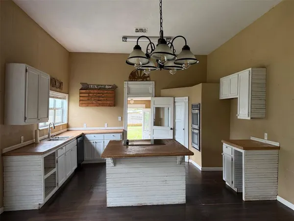 a kitchen with granite countertop a sink stainless steel appliances and cabinets