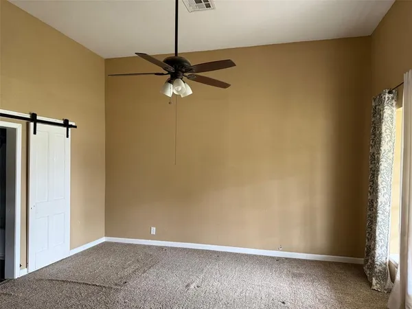 an empty room with a window and a fan