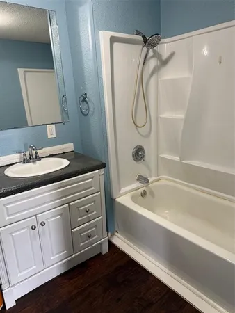 a bathroom with a granite countertop sink a toilet a mirror and shower