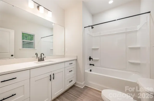 a bathroom with a granite countertop sink toilet tub and shower