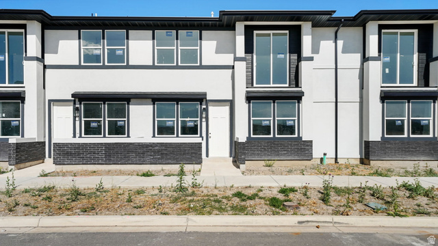717 South Harrison Drive West Springville, UT 84663 - Photo 3 of 31 Modern townhome exterior featuring clean lines and a white stucco finish