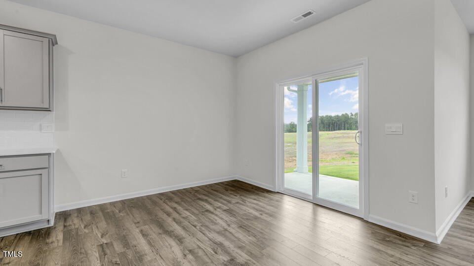 806 Comice Pear Way Willow Spring, NC 27592 - Photo 14 of 37 a view of an empty room with wooden floor and a window