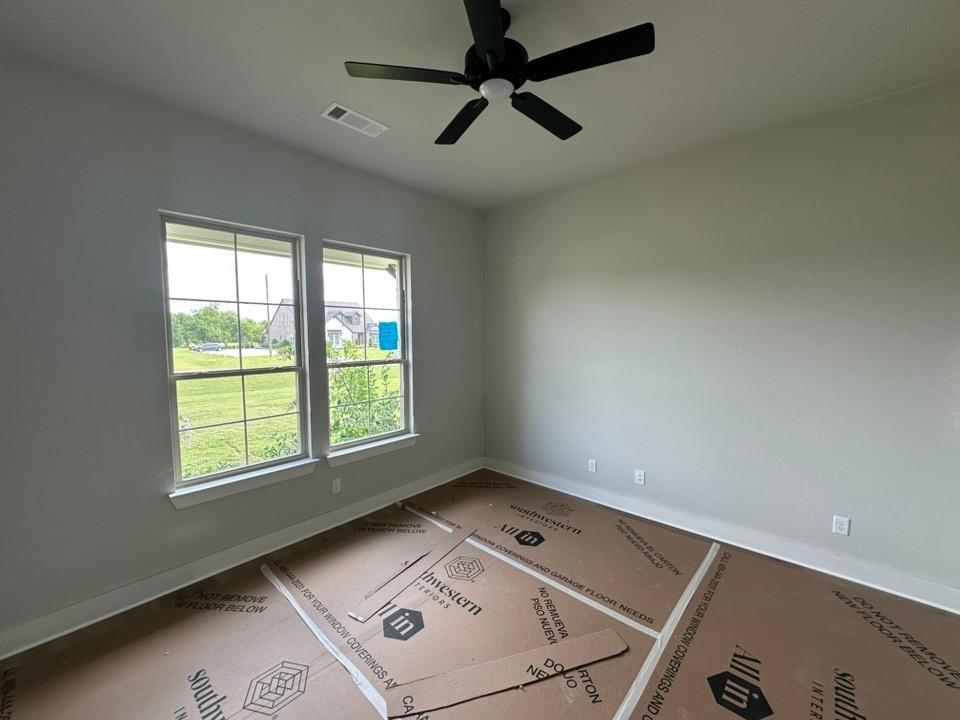 295 Brown Road Leonard, TX 75452 - Photo 5 of 28 Room featuring two large windows with exterior views, light-toned walls, a black ceiling fan, and white trim