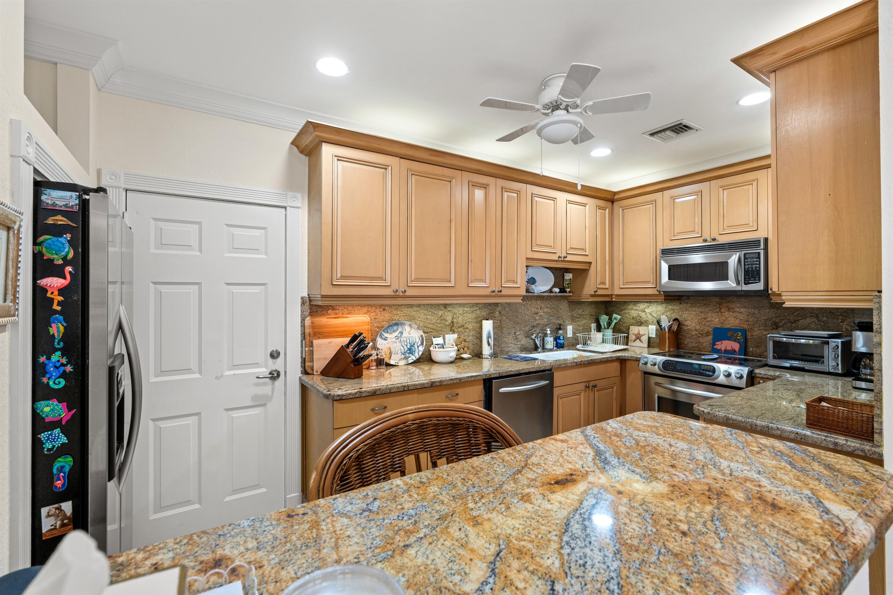 5900 Old Ocean Boulevard, Unit B5 Ocean Ridge, FL 33435 - Photo 5 of 21 a kitchen with stainless steel appliances granite countertop a refrigerator stove top oven a sink and dishwasher