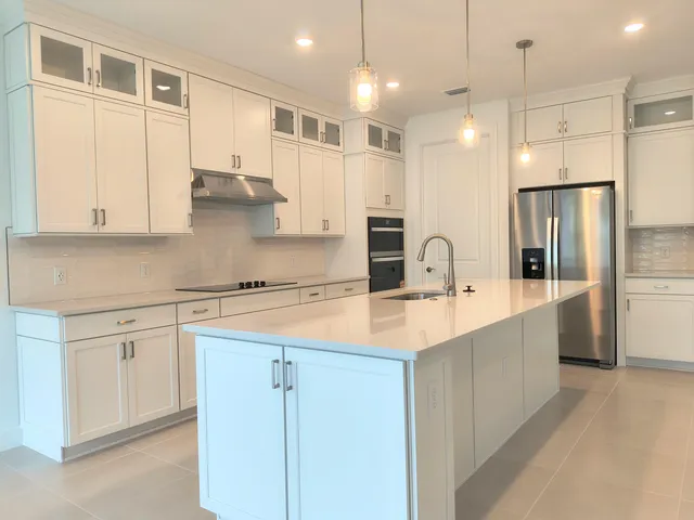 a large kitchen with kitchen island a sink a center island stainless steel appliances and cabinets