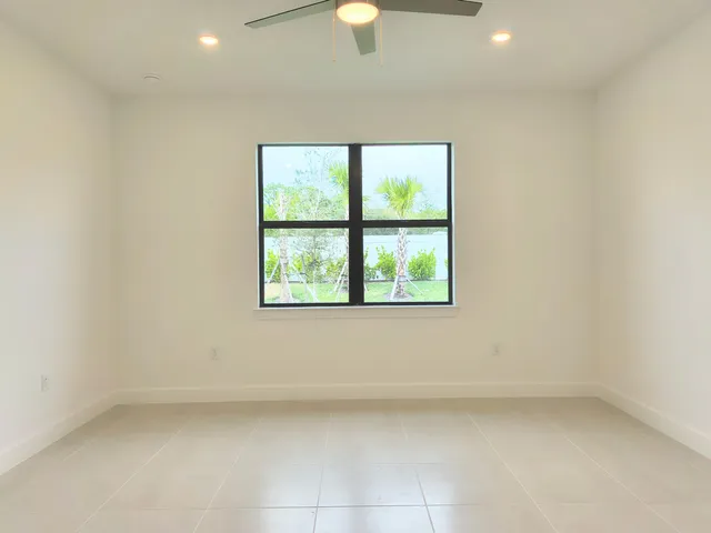 an empty room with windows and fan