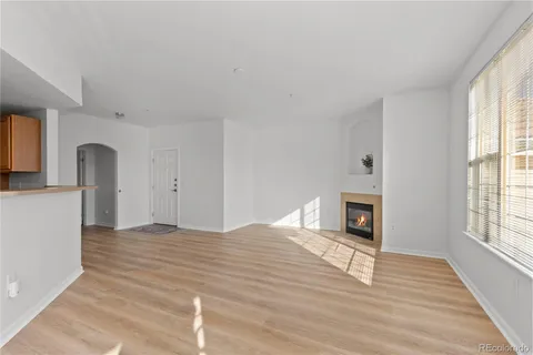a view of empty room with wooden floor and fireplace