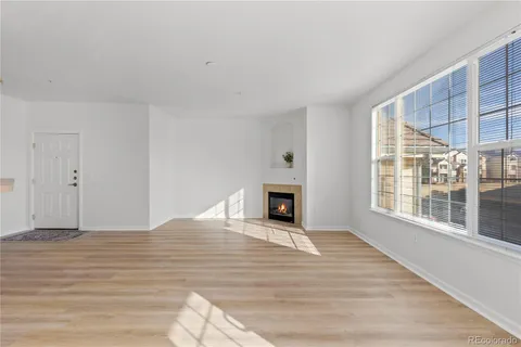 a view of empty room with wooden floor and fireplace