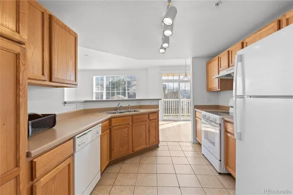 a kitchen with stainless steel appliances granite countertop a refrigerator a sink dishwasher a stove with white cabinets