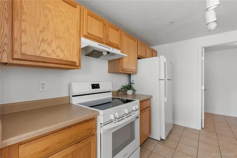 a kitchen with stainless steel appliances granite countertop a refrigerator a stove and a sink