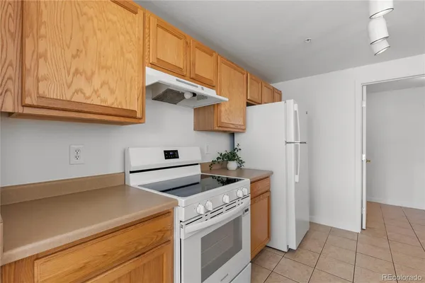 a kitchen with stainless steel appliances granite countertop a refrigerator a stove and a sink