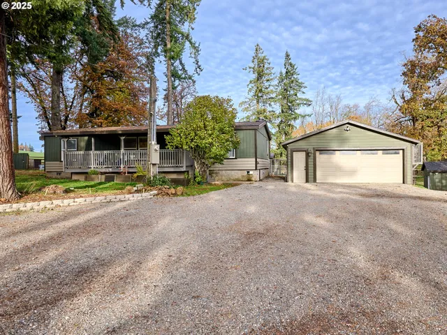 a view of a house with a yard and large tree