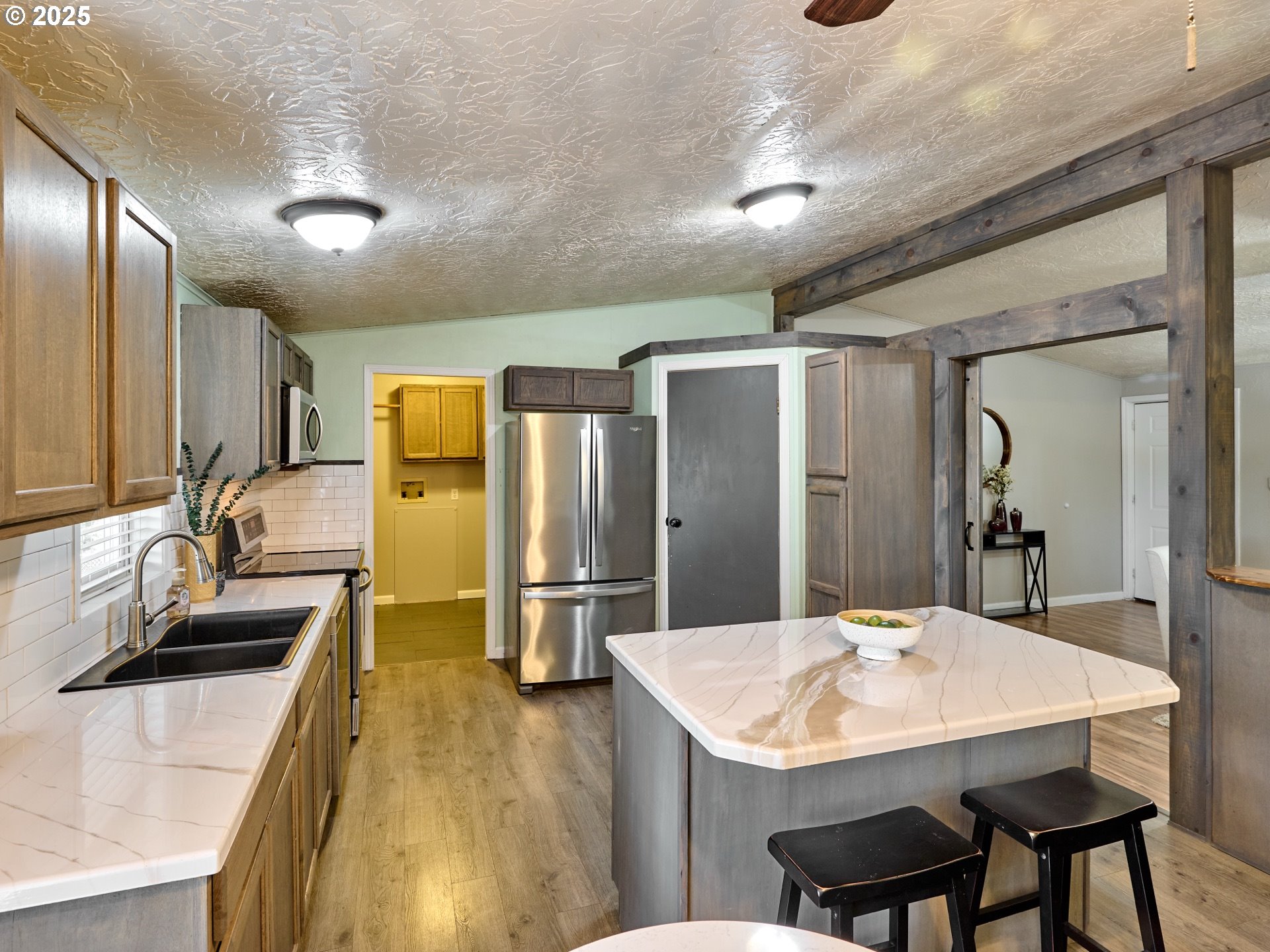 6288 Sherman Road Southeast Aumsville, OR 97325 - Photo 10 of 45 a kitchen with stainless steel appliances kitchen island granite countertop a sink and refrigerator