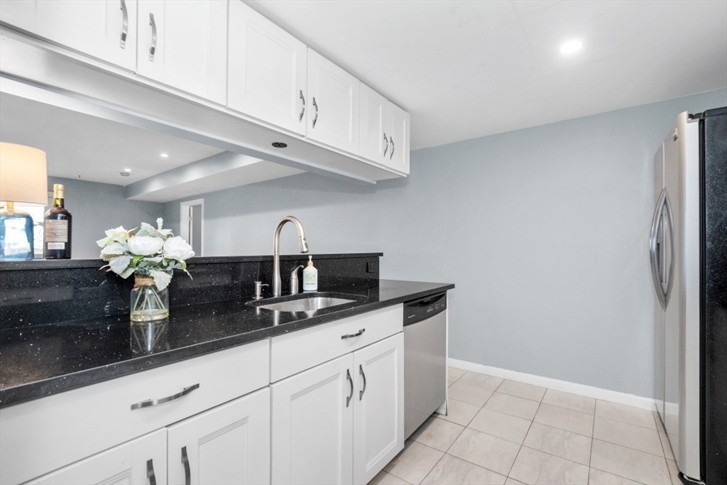 165 Cottage Street, Unit 410 Chelsea, MA 02150 - Photo 2 of 25 a kitchen with granite countertop a sink and cabinets