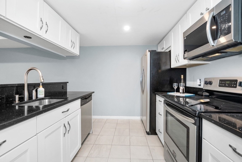 165 Cottage Street, Unit 410 Chelsea, MA 02150 - Photo 3 of 25 a kitchen with stainless steel appliances granite countertop a sink and a stove