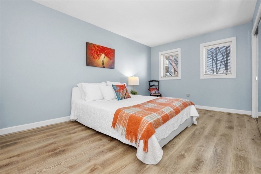 165 Cottage Street, Unit 410 Chelsea, MA 02150 - Photo 7 of 25 a bedroom with a bed and painting on the wall