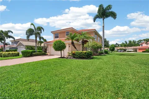 a front view of a house with a yard and a garden