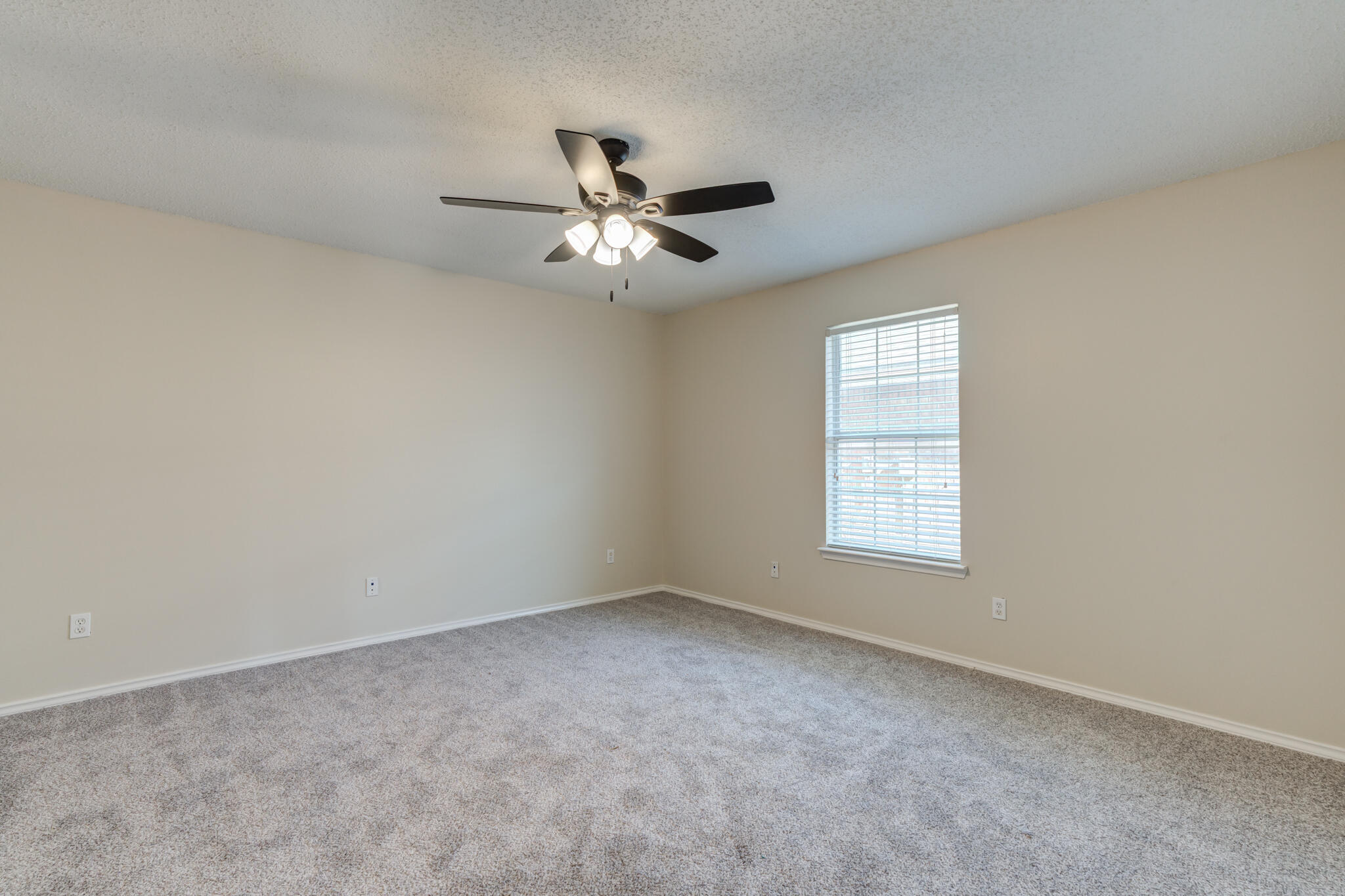 6713 85th Street Lubbock, TX 79424 - Photo 12 of 16 an empty room with a window and a ceiling fan