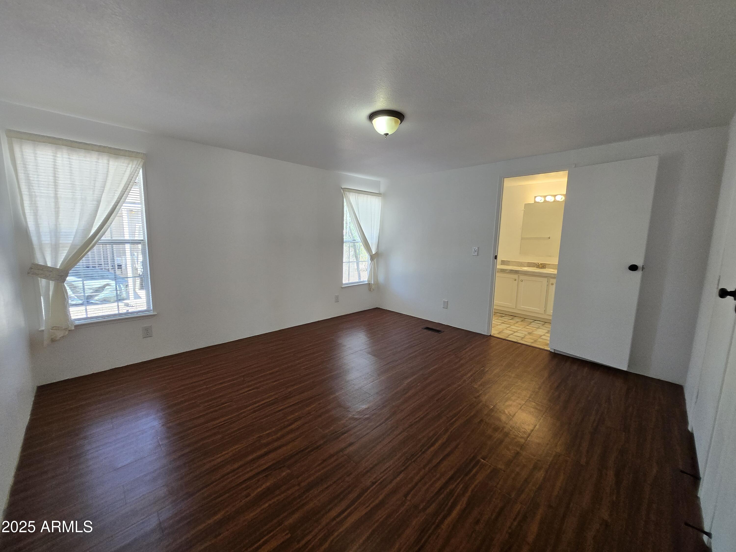 2000 South Apache Road, Unit 87 Buckeye, AZ 85326 - Photo 14 of 29 an empty room with wooden floor and windows