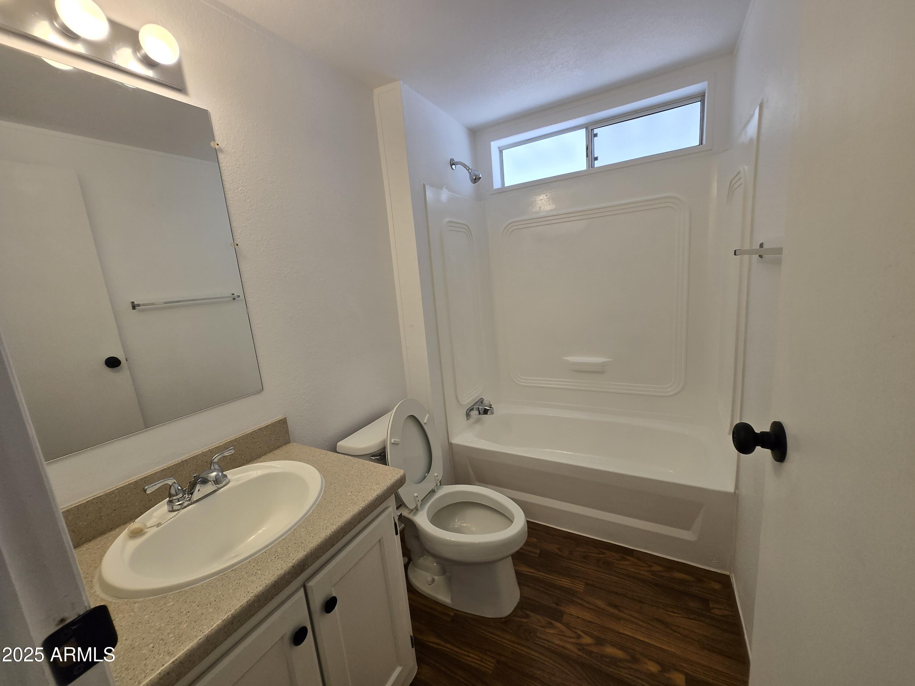 2000 South Apache Road, Unit 87 Buckeye, AZ 85326 - Photo 19 of 29 a bathroom with a granite countertop toilet a sink and a mirror