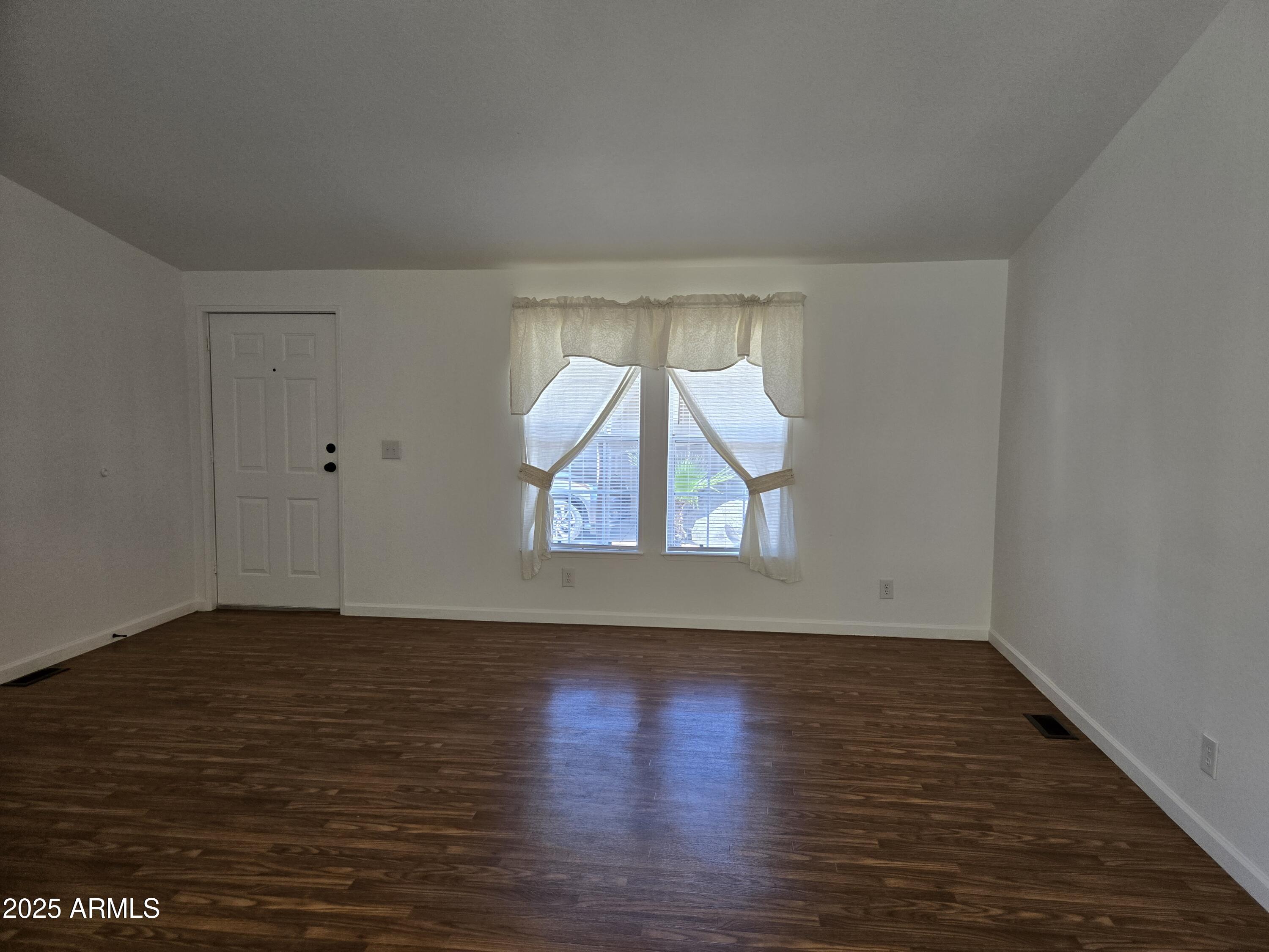 2000 South Apache Road, Unit 87 Buckeye, AZ 85326 - Photo 5 of 29 an empty room with wooden floor and windows