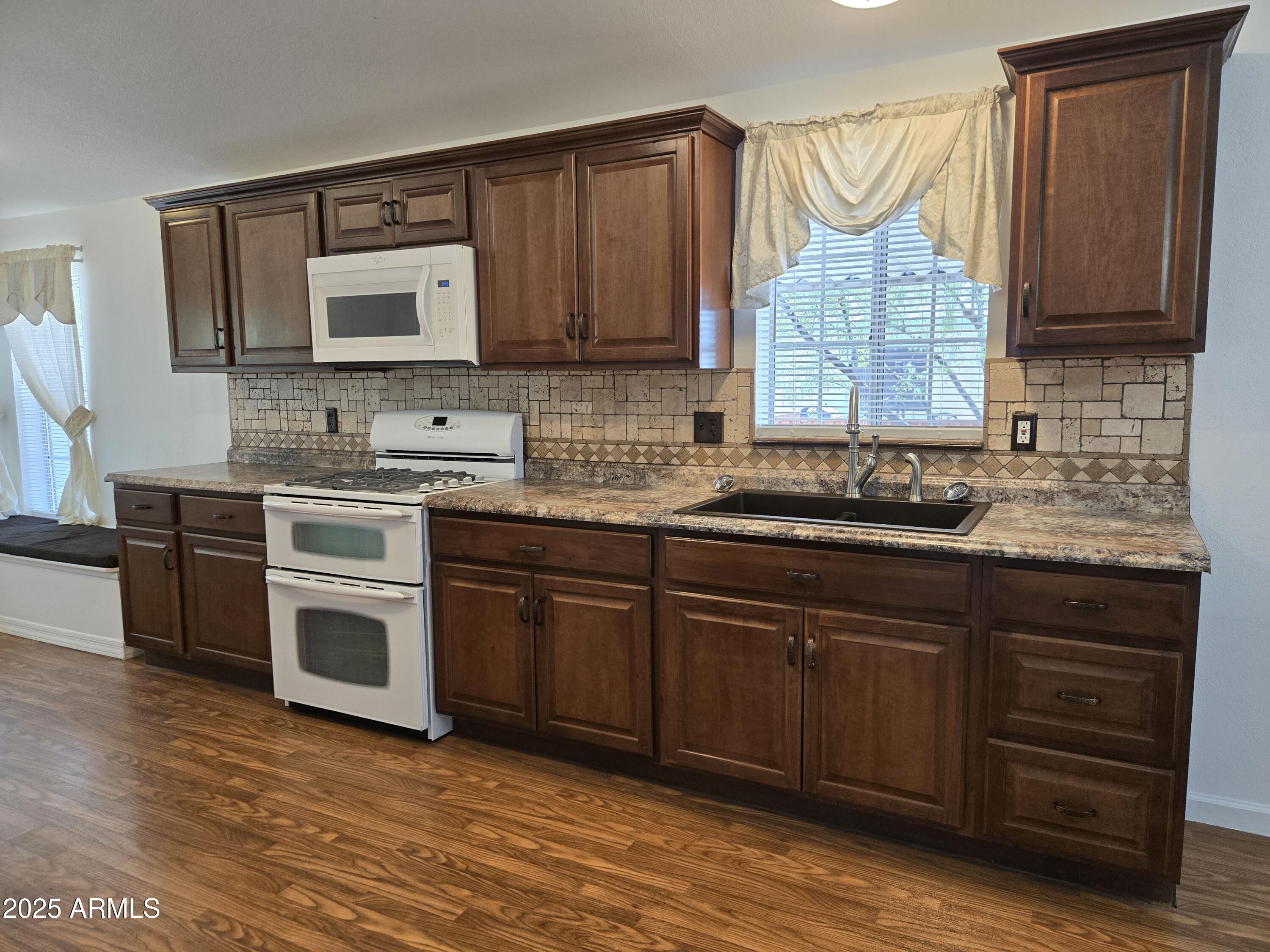 2000 South Apache Road, Unit 87 Buckeye, AZ 85326 - Photo 10 of 29 a kitchen with stainless steel appliances granite countertop a stove sink and cabinets